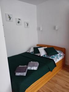 - une chambre avec un lit doté de draps et d'oreillers verts dans l'établissement ,,Zielona przystań nad morzem" Gdańsk - Przymorze, à Gdańsk