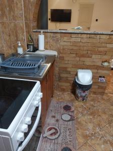 kuchnia z kuchenką, zlewem i toaletą w obiekcie HARMÓNIA HÁZ w mieście Makó