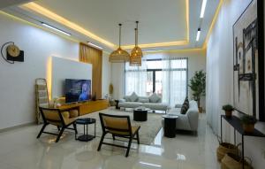 uma sala de estar com um sofá, uma mesa e cadeiras em Al Bandar Luxury Villa with 5BHK with private pool em Fujairah