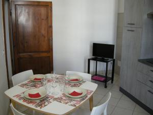 a table with glasses and plates on it in a kitchen at Civico10, appartamento centrale con parcheggio e terrazzo in Piombino +11 photos