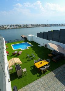 einen Balkon mit einem Tisch, Stühlen und einem Pool in der Unterkunft Al Bandar Luxury Villa with 5BHK with private pool in Fudschaira