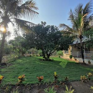 um quintal com palmeiras e uma casa em Kasturi Villa - A home away from home em Mandve