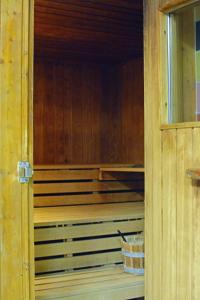 une porte ouverte d'un sauna en bois avec un panier dans l'établissement Hotel Restaurant Piccard, à Flessingue