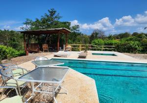 a swimming pool with two chairs and a gazebo at LiberaLiCostaRica in Marbella