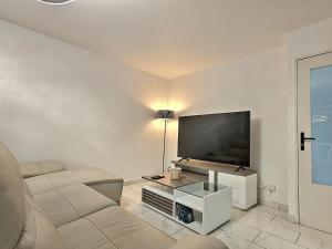 a living room with a couch and a flat screen tv at RESIDENCE SERENA in Torcy