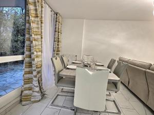 a dining room with a table and chairs and a window at RESIDENCE SERENA in Torcy