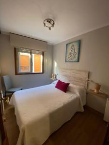 a bedroom with a large white bed with a red pillow at CASA DA REGUEIRA in Redondela