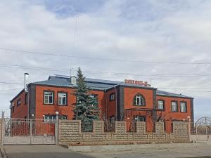 a brick building with a fence in front of it at Erazank Hotel in Gyumri
