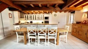 een keuken met een houten tafel en stoelen bij Logis du paradis in Criteuil-la-Magdeleine