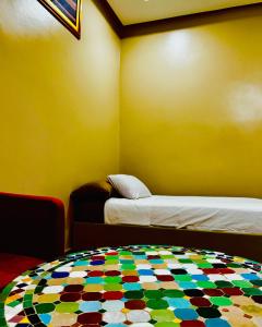 a room with two beds and a colorful floor at COMPLEXE L'OASIS in Erfoud