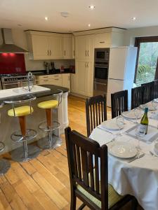 a kitchen with two tables and a kitchen with white cabinets at Trebarried Mill in Brecon