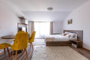 een slaapkamer met een bed en een tafel en stoelen bij Pirin Sense Apartment Complex in Bansko