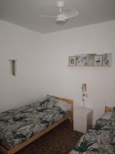 a bedroom with a bed and a night stand with a lamp at La fuente in Güéjar-Sierra