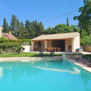 a swimming pool in front of a house at La Bastide des Arts in Saumane-de-Vaucluse