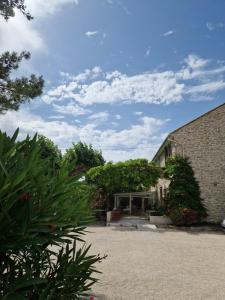 un edificio con árboles y plantas en un patio en La Bastide des Arts, en Saumane-de-Vaucluse