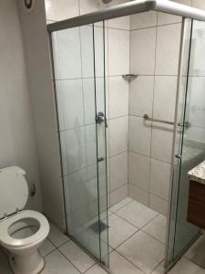 a bathroom with a glass shower with a toilet at Ecologic Ville Resort Apto há 900 mt do centro de Caldas Novas in Caldas Novas