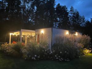 ein kleiner Schuppen mit Licht in einem Garten in der Nacht in der Unterkunft Orzyny Summer House in Orzyny