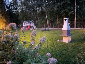 einen Garten mit einem Vogelhaus und einem Spielplatz in der Unterkunft Orzyny Summer House in Orzyny