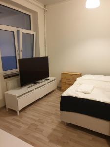 a bedroom with a bed and a flat screen tv at The old school motell & lägenheter in Marma