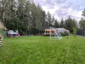 einen Hof mit Spielplatz mit Schaukel in der Unterkunft Orzyny Summer House in Orzyny