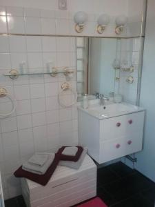 La salle de bains est pourvue d'un lavabo et d'un miroir. dans l'établissement La roseraie, à Aytré