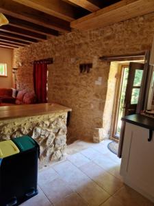 salon z kamiennym kominkiem w domu w obiekcie Gîtes Le clos de Veyrignac w mieście Veyrignac
