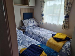 two twin beds in a room with a window at Georgia Lodge in Knaresborough