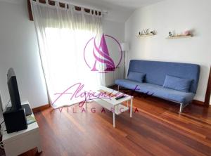 sala de estar con sofá azul y mesa en Ático Doctor Fleming, en Vilagarcía de Arousa