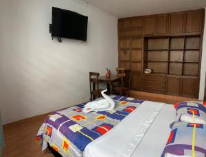 a bedroom with a bed with a toy animal on it at Hostel Morobik and outdoor brunch in Popayan