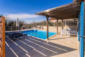 een patio met een zwembad en een houten pergola bij Casa Nadalina in Višnjan