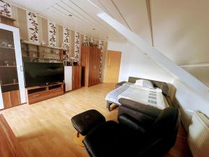 sala de estar con sofá y TV en Ferienwohnung Hochwaldblick 2, en Morbach