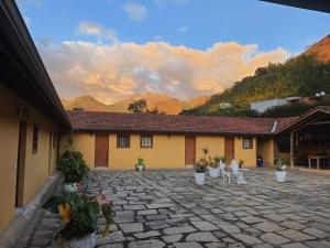 a building with a stone courtyard with white chairs at Barão do Vale in Itaipava