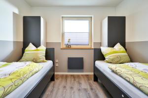 Duas camas num quarto com uma janela em Appartement Amelanderoase 82 im Amelander Paradijs em Buren