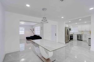 cocina blanca grande con mesa y sofá en 4 bedroom 3 bath villa, en Fort Lauderdale