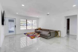sala de estar con sofá y alfombra en 4 bedroom 3 bath villa, en Fort Lauderdale