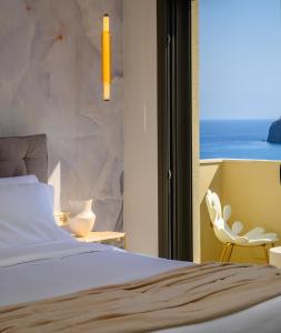 a bedroom with a bed and a view of the ocean at KALOS LUXURY HOMES, BEACHSIDE EXPERIENCE VOULISMA in Istron