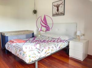 Un dormitorio con una cama con un cartel. en Ático Doctor Fleming, en Vilagarcía de Arousa