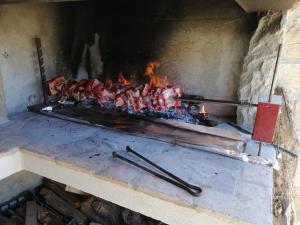a fireplace with meat cooking on top of it at Casa di Pietra in Usellus
