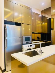 a kitchen with a sink and a refrigerator at Crystal Suite at Dorsett Bukit Bintang KL in Kuala Lumpur