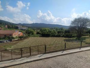 una valla al lado de una carretera con un campo en Apartamento Gandía, Orihuela del Tremedal., en Orihuela del Tremedal