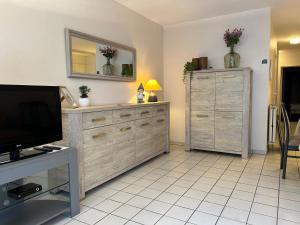a living room with a television and a dresser at App Zeelaan A2 in Koksijde