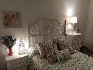 1 dormitorio con cama con almohadas y espejo en Apartamento Gandía, Orihuela del Tremedal., en Orihuela del Tremedal