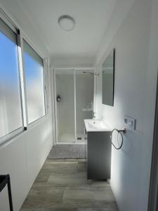 a white bathroom with a shower and a sink at Apartamento El Castell in Alaquas
