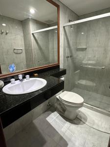 a bathroom with a sink and a toilet and a mirror at Hotel Prince Plaza in Medellín