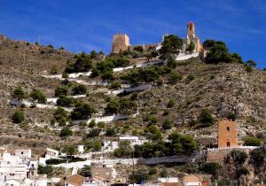 einen Hügel mit einem Schloss darüber in der Unterkunft 150m2 Con vistas al Mar y al Castillo de Cullera in Cullera