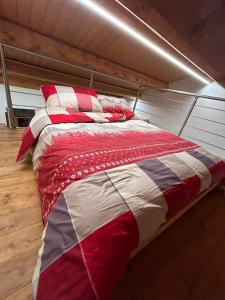 Ostana的住宿－BAITA GHITIN，一张红色和白色的床铺