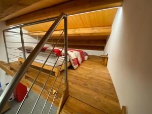an attic room with a bunk bed and a staircase at BAITA GHITIN in Ostana