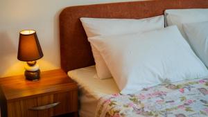 a bedroom with a bed with a lamp on a night stand at Apartmani Ana in Tivat