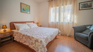 a bedroom with a bed and a chair and a window at Apartmani Ana in Tivat