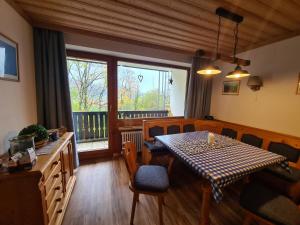 a dining room with a table and chairs and a window at Ferienwohnung im kuhlen Allgäu in Missen-Wilhams